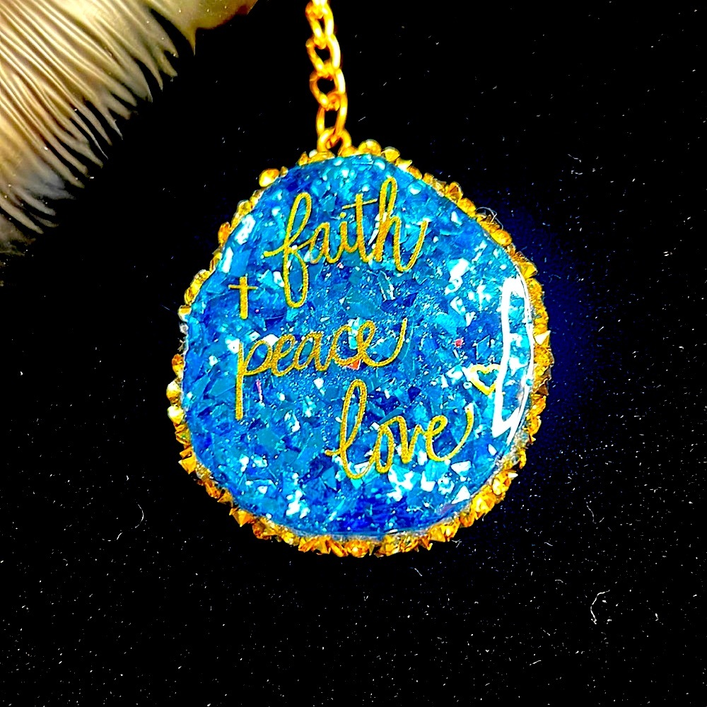 Resin keychain. Blue with gold trim & “Faith, Peace & Love” in gold writing💛